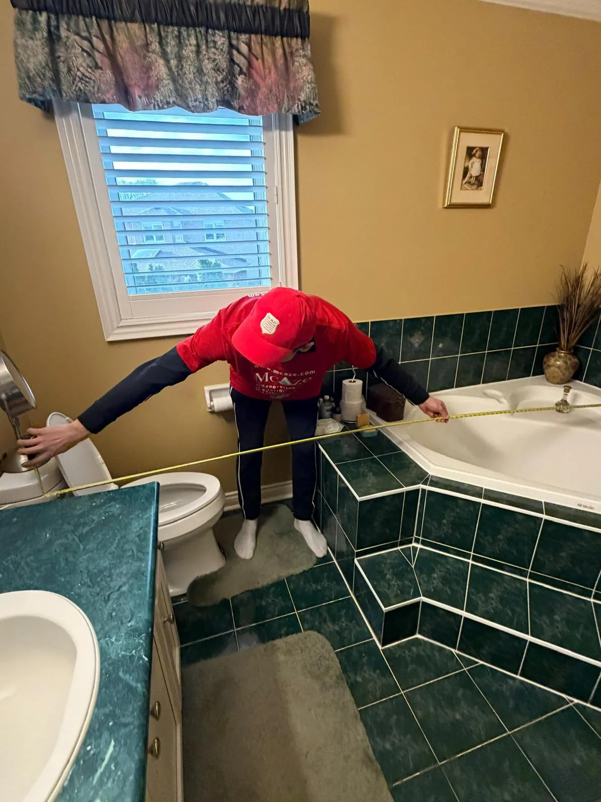 McAze measuring an existing bathroom before a full renovation in the Greater Toronto Area