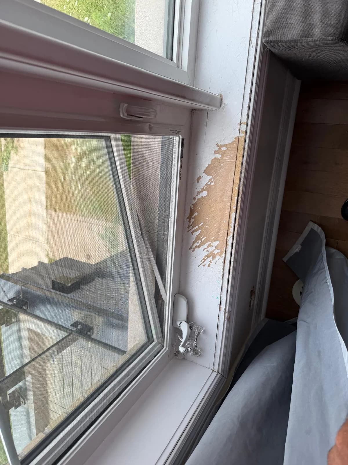 Peeling window frame finish before townhouse renovation