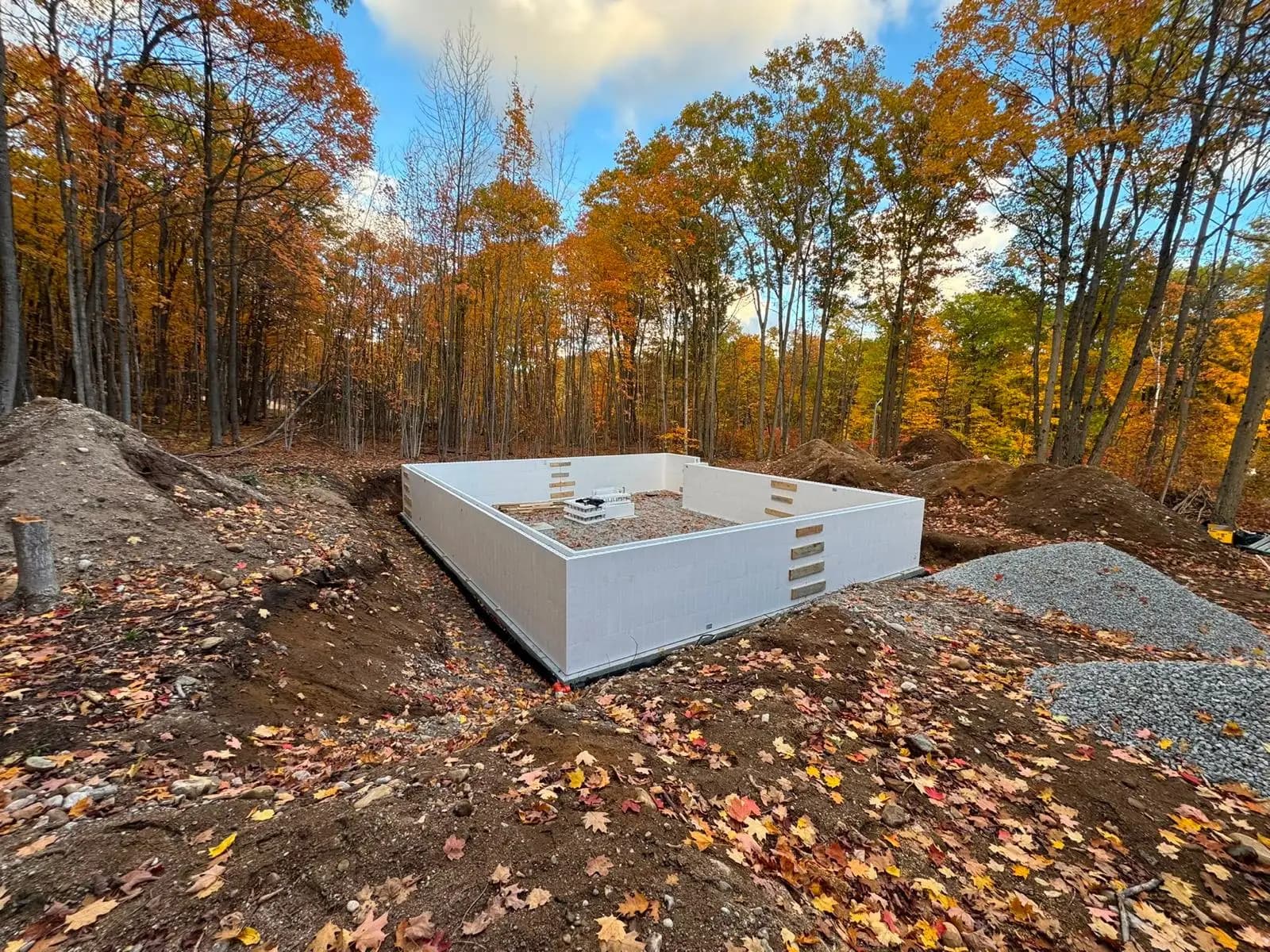 Wide view of ICF home foundation construction on wooded Barrie terrain