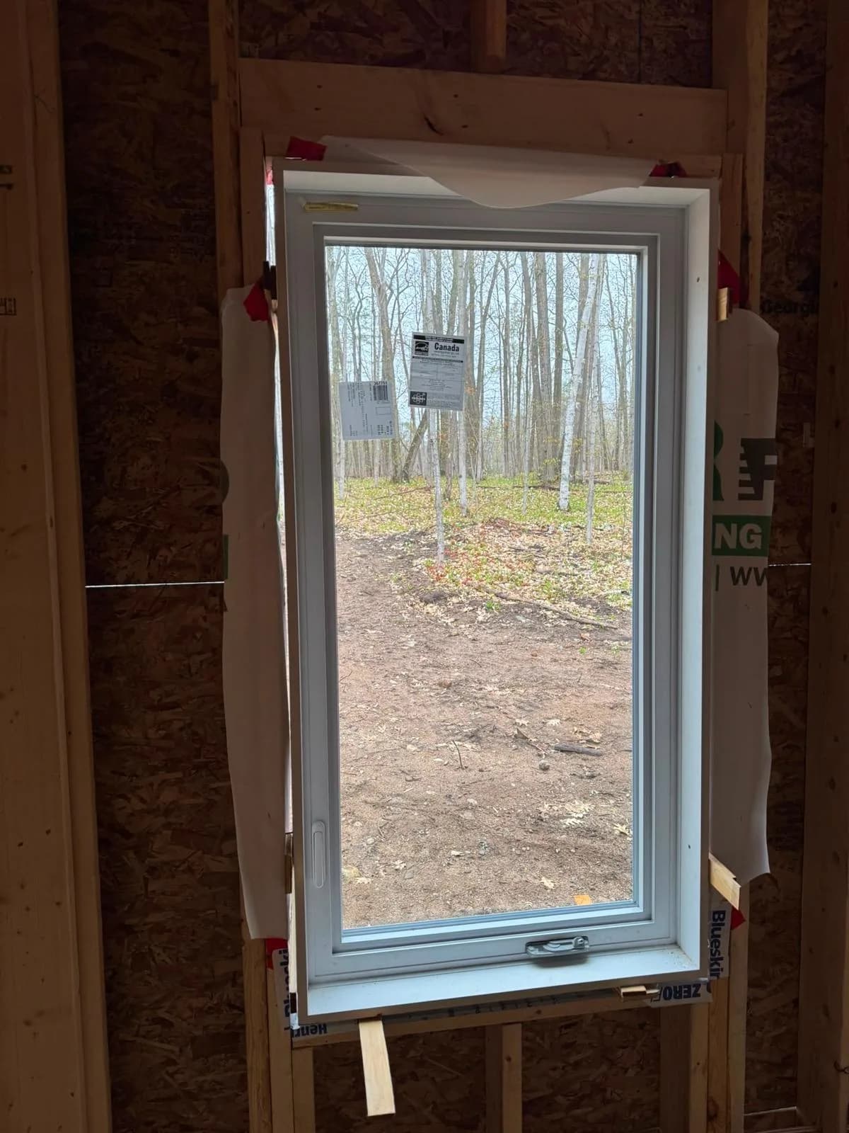New casement window installation viewed from unfinished interior framing