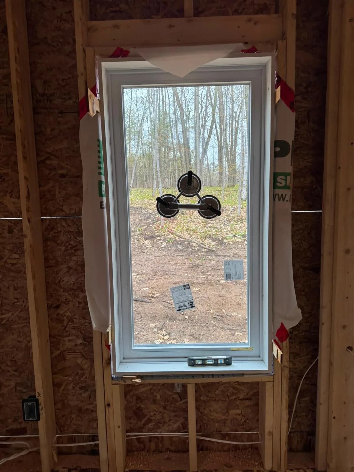 Installer level used to verify a new window frame before interior finishing
